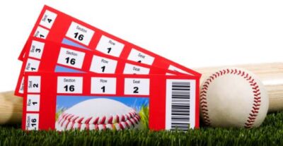 A baseball in grass against a blue sky background